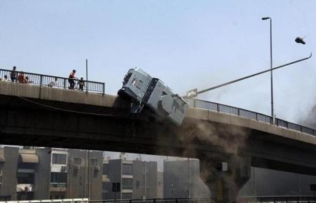A police vehicle is pushed off of a bridge in Cairo by protesters close to the largest sit-in by supporters of ousted president Mohammed Morsi.
